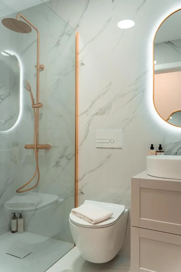Casa de banho do T2 em mármore branco com torneiras em latão escovado dourado